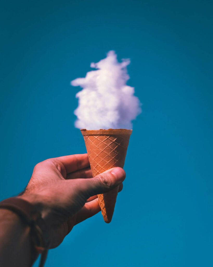 Ein Mann hält eine Eiswaffel mit einer Wolke oben darauf, als Symbol für die verschiedenen Cloud-Versionen von SAP S/4HANA