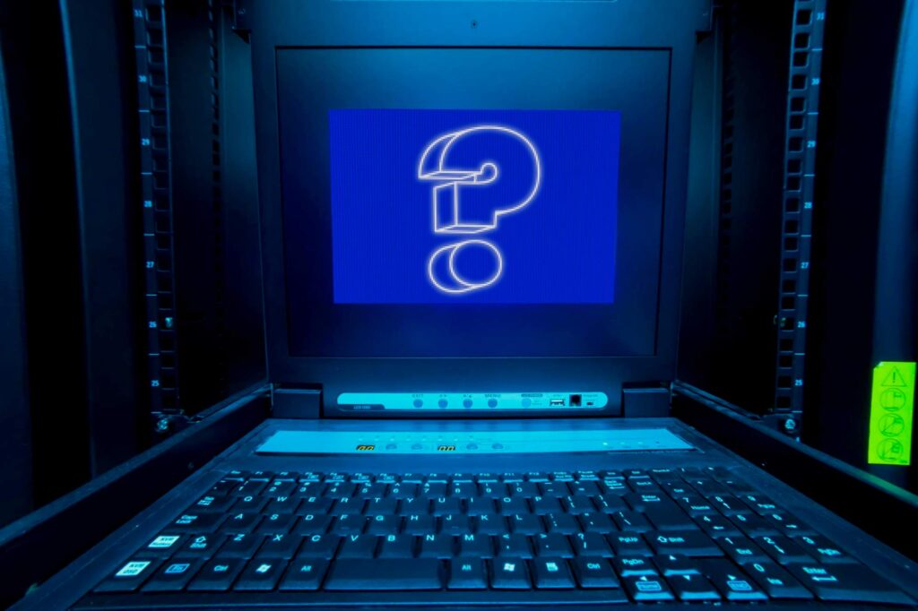 In einem Serverraum wird ein Rack KVM Konsole, also ein ausziehbarer Monitor mit Tastatur für die Serverwartung, aufgeklappt. Das Display zeigt einen blauen Bildschirm mit einem weißen Fragezeichen darauf. Es steht für das Kapitel FAQ im Artikel über SAP Archivierung. 